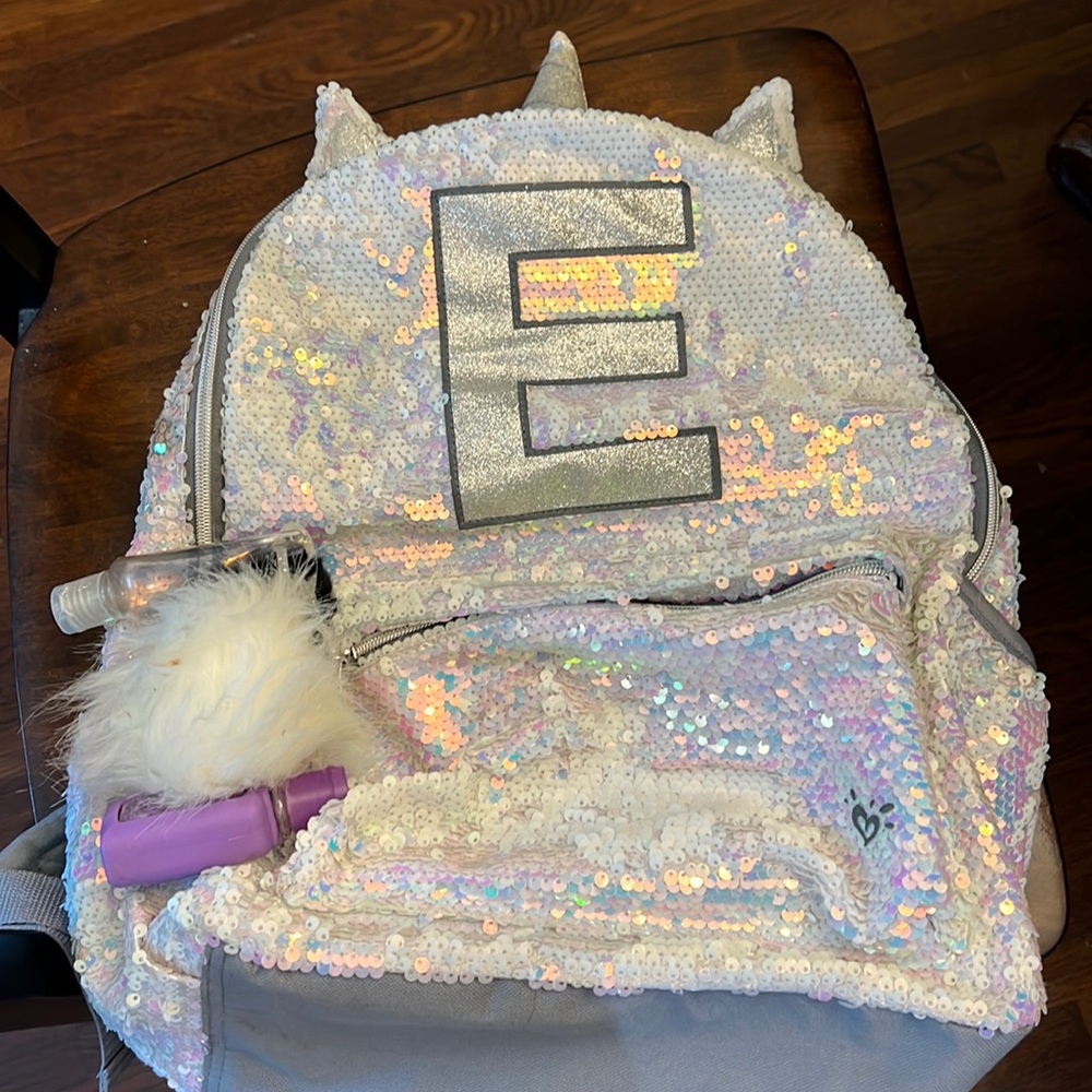 Cute unicorn sequined initial backpack with Pom poms attached.